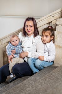 Das Portrait von Marta Yildiz zeigt sie mit ihren beiden Kindern auf den Stufen sitzend