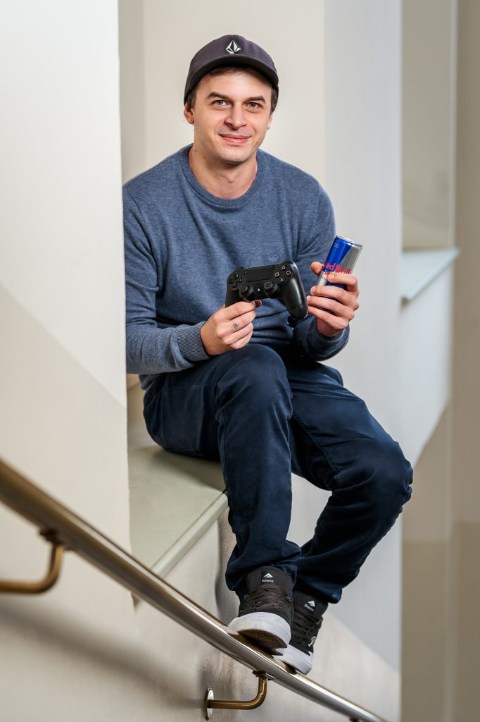 Das Portrait von Martin Zagar zeigt ihn einen Gaming-Controller und eine Energy-Drink Dose haltend