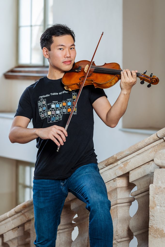Das Portrait von Michael Hsieh zeigt ihn auf einer Geige spielend