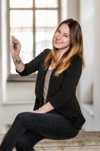 Das Portrait von Milica Lucic zeigt sie einen USB-Stick in Tatzenform haltend