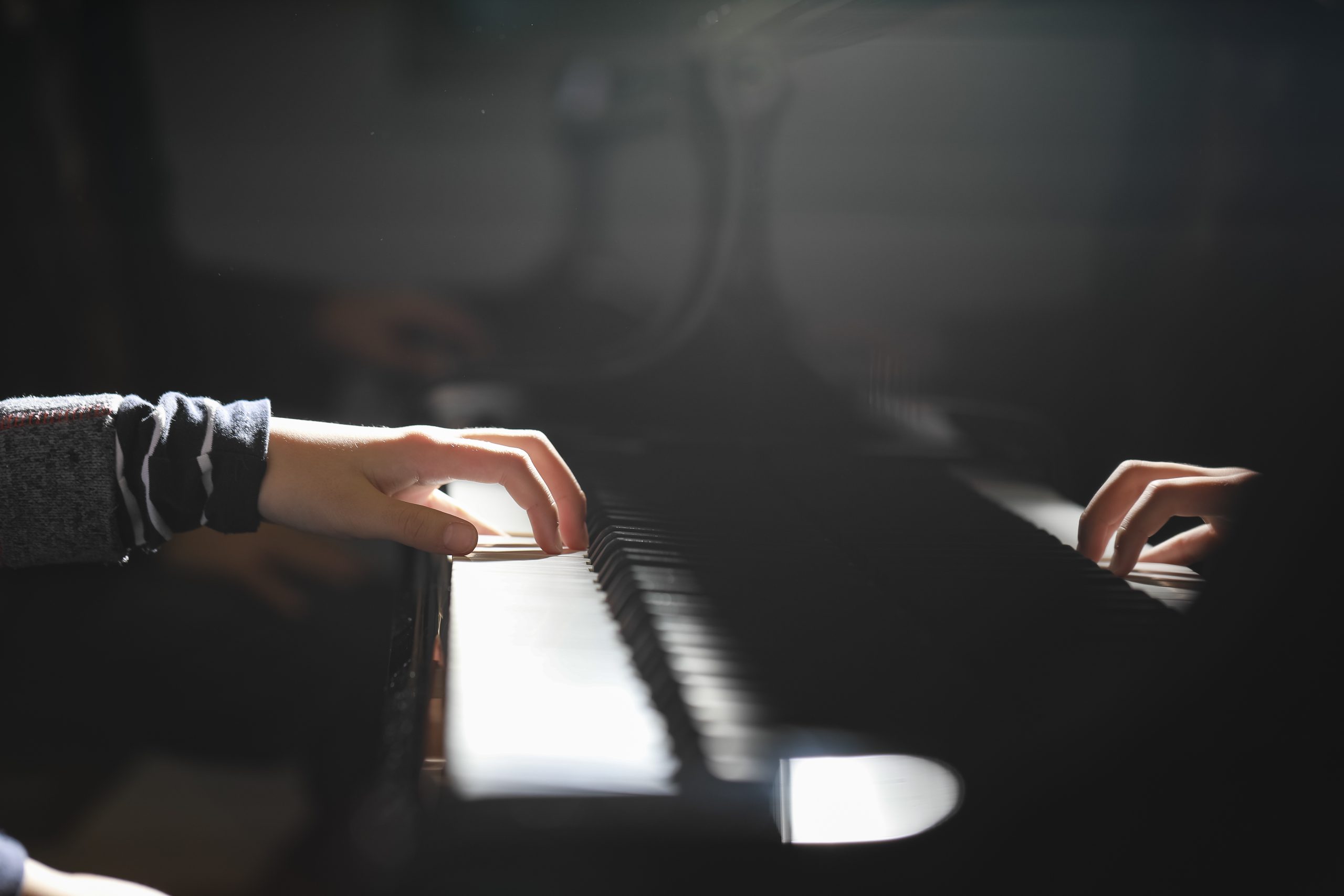 Eine Hand liegt auf den Tasten eines Klaviers